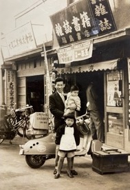 昭和33年（1958）頃、２階を住居にしていた新町の店の前で（手前は福島社長）。「平凡と明星の発売日には早朝から行列が出来ていたので、それを見てオヤジは開店を早めていました」（福島社長）